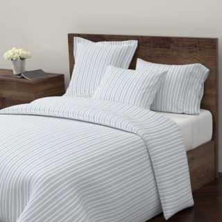 Blue ticking bedspread in n farmhouse Decor Lovers Gift Guide.